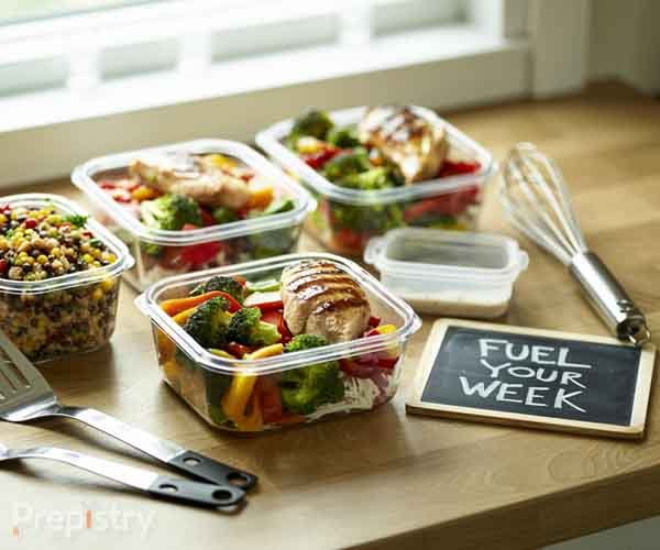 Organized meal prep containers with colorful, healthy meals and cooking tools showcasing complete meal preparation system